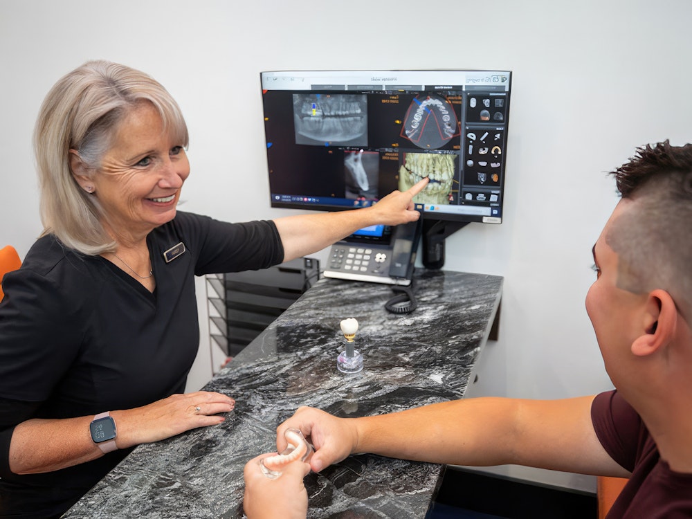 NuSmile dental professional educating patient about implants